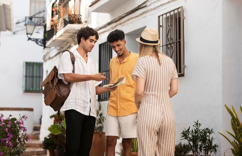 A traveler holding a map and consulting with local Spanish speakers, demonstrating practical use of Spanish phrases in conversation.